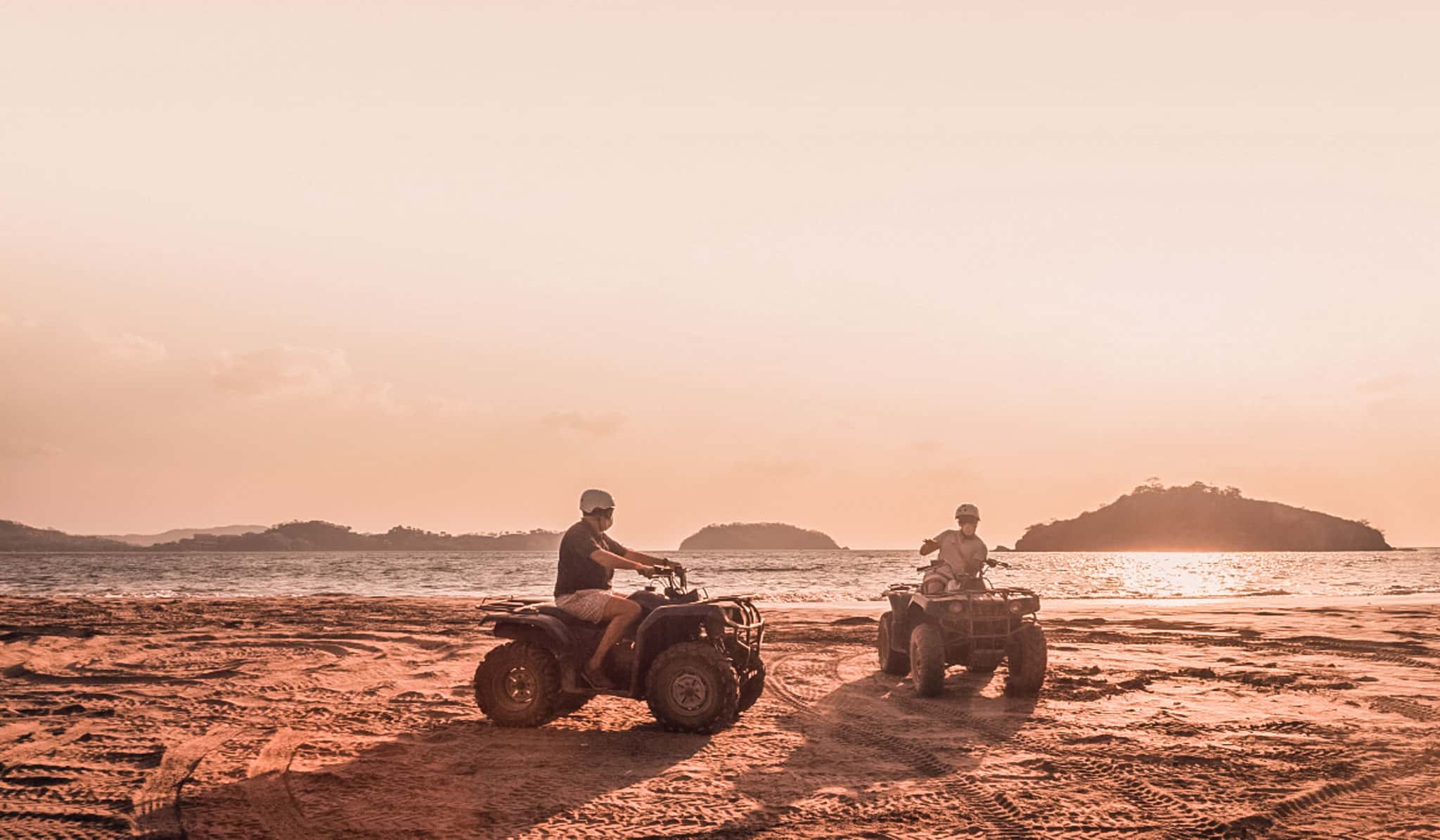Two men on ATV's on beach in Costa Rica
