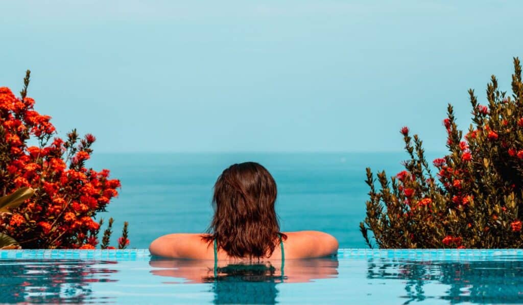 View of a woman looking out at the ocean from an infinity pool in Mal Pais, Costa Rica