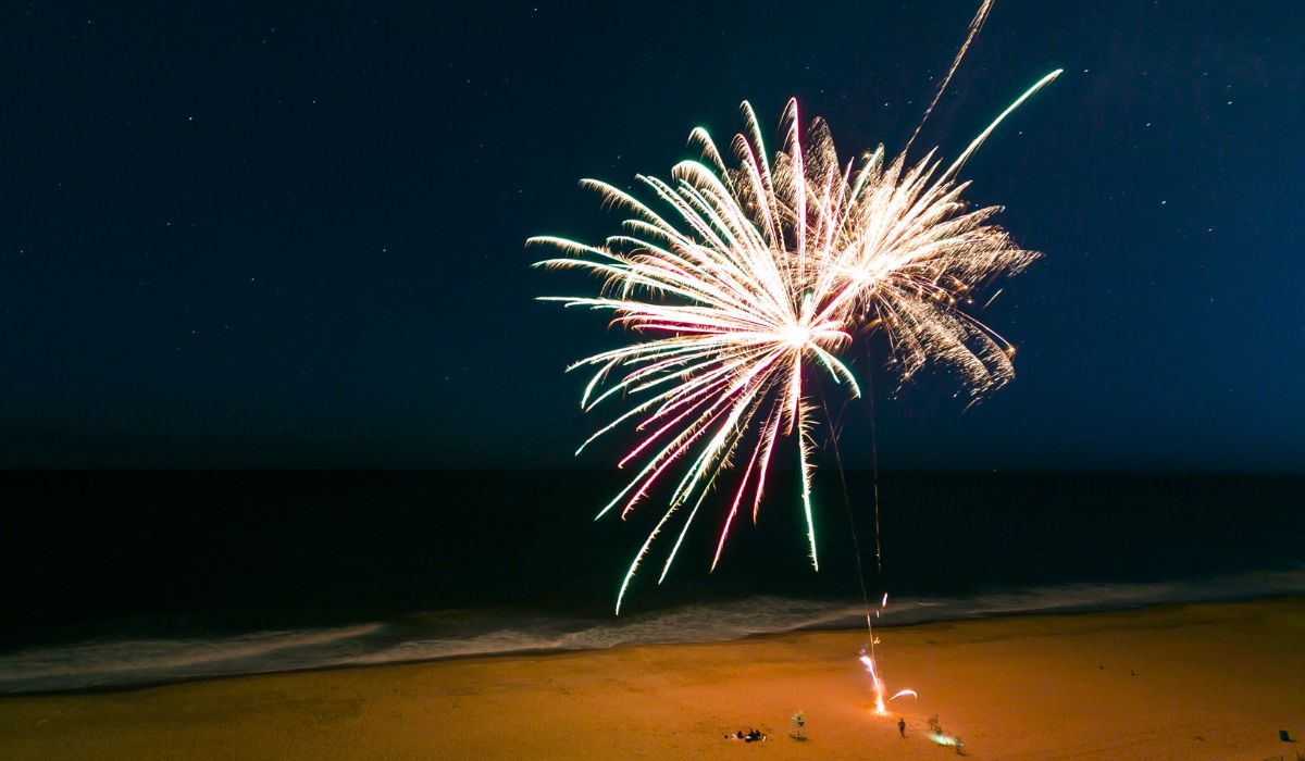white fireworks at night over beach