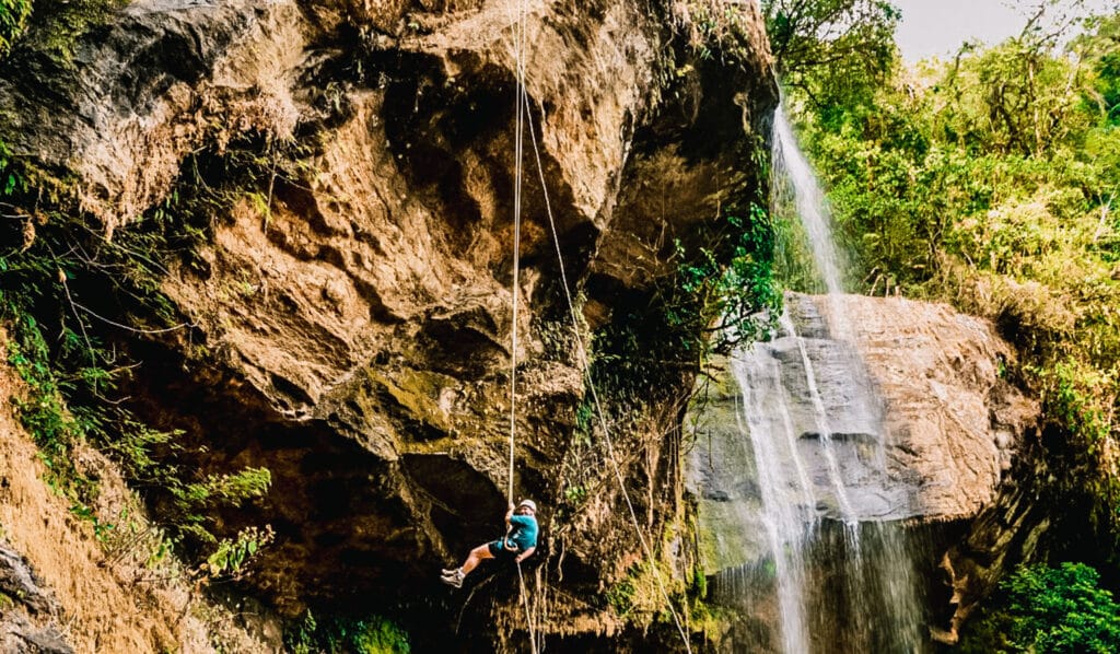 A man rappelling down a cliff side in Costa Rica